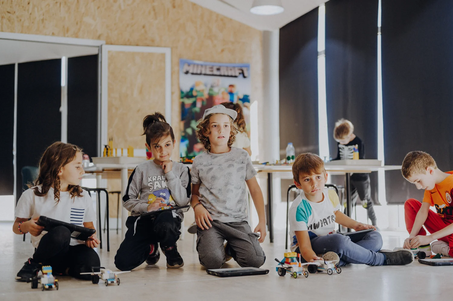 Children taking part in a robotics workshop with tablets and models